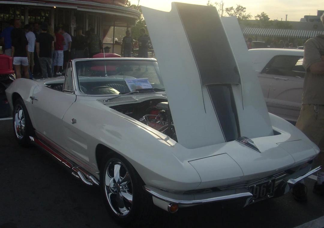 White 1963 Chevrolet Corvette convertible with the hood open at a car show