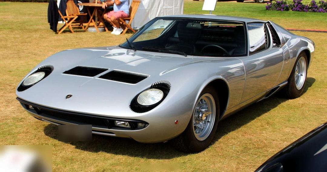 Orange 1968 Lamborghini Miura P400, full side and front view at a concours