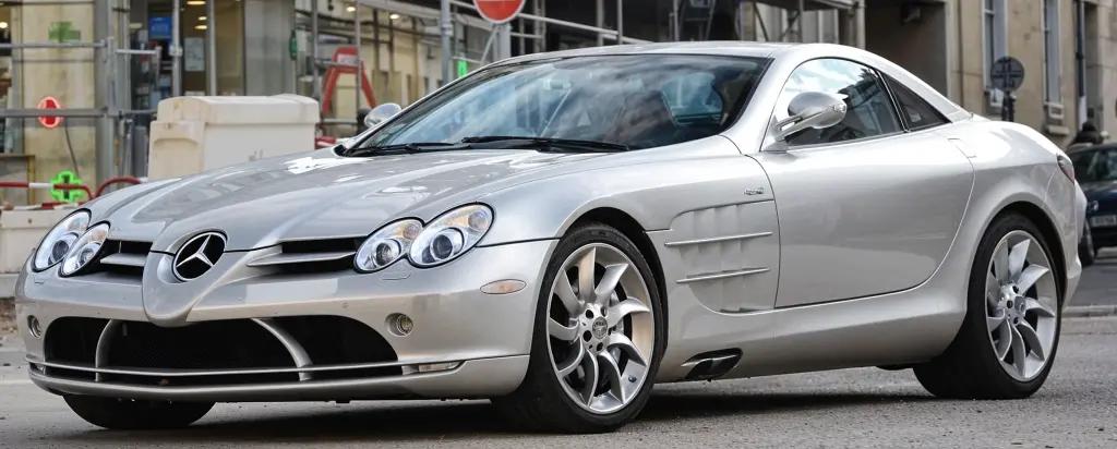Mercedes-Benz SLR McLaren in silver, parked in front of a city skyline