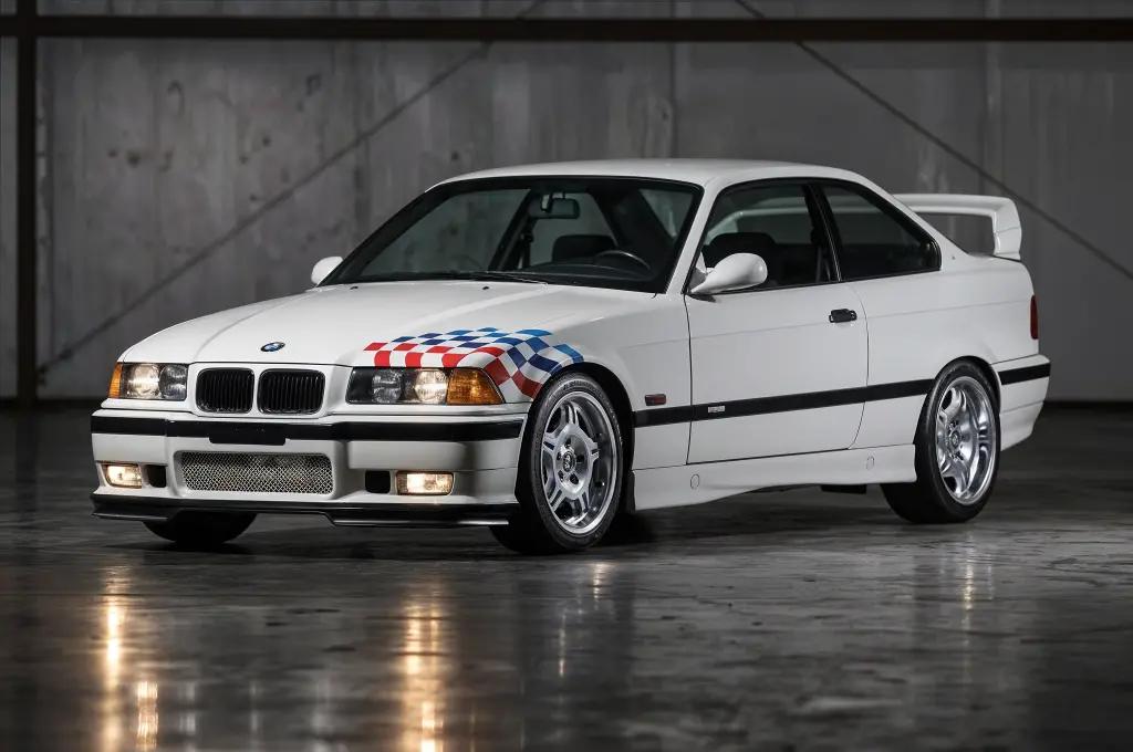 BMW E36 M3 Lightweight in Alpine White, parked on a racetrack